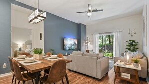 Una sala moderna con comedor, sofá y ventilador de techo.