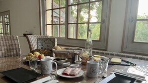 Una mesa de desayuno dispuesta con diversos alimentos, una botella y una tableta.