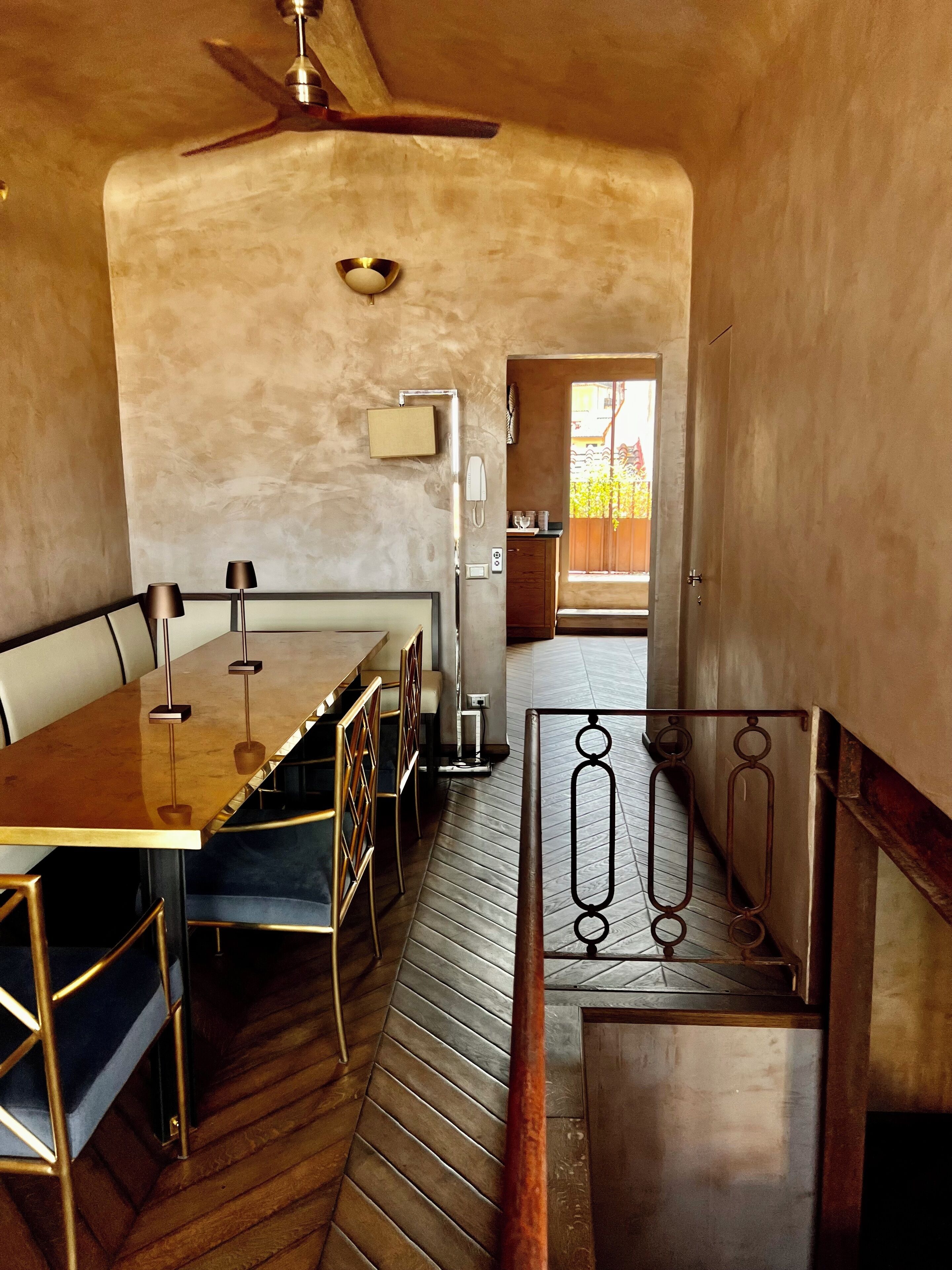 Ein Essbereich mit Holztisch und -stühlen, einem Deckenventilator und Blick ins Freie.