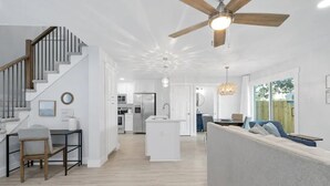 Un espace de vie moderne comprenant un escalier, une cuisine et un coin repas.