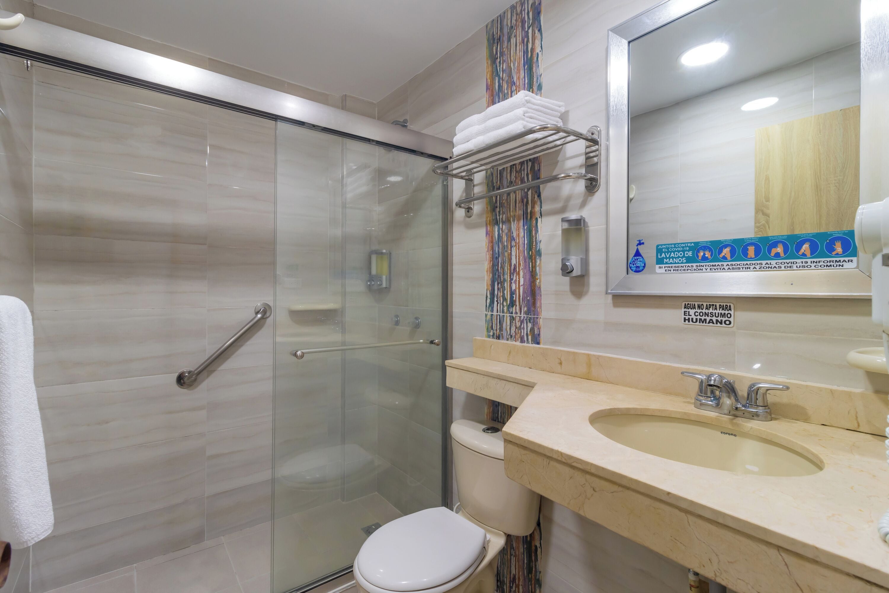 A modern bathroom with a glass-enclosed shower, a toilet, and a sink with a vanity.