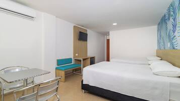 Habitación de hotel con cama, escritorio, silla, televisión y ventana con vistas.