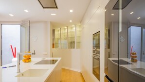 Une cuisine moderne avec des meubles blancs, un îlot central et des appareils électroménagers intégrés.