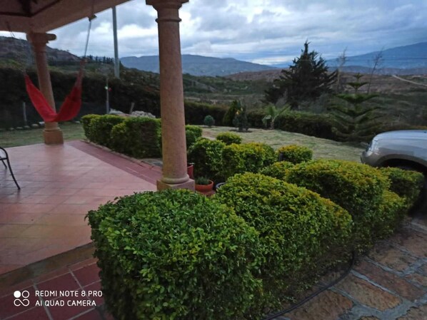 Stroll through the beautifully maintained garden, surrounded by rolling hills and a distant mountain range.