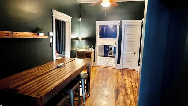 Une cuisine dotée de plans de travail en bois, d’un coin bar et d’un ventilateur de plafond.