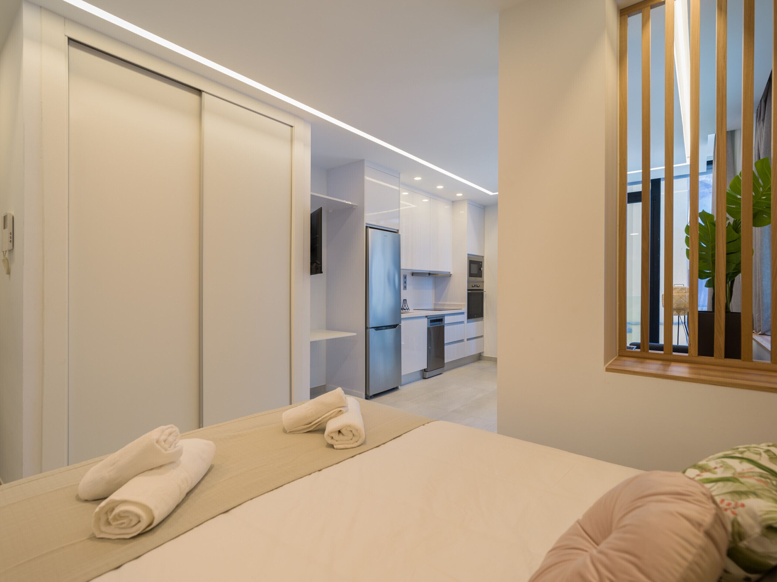 Una habitación de hotel moderna con cama, baño y kitchenette.