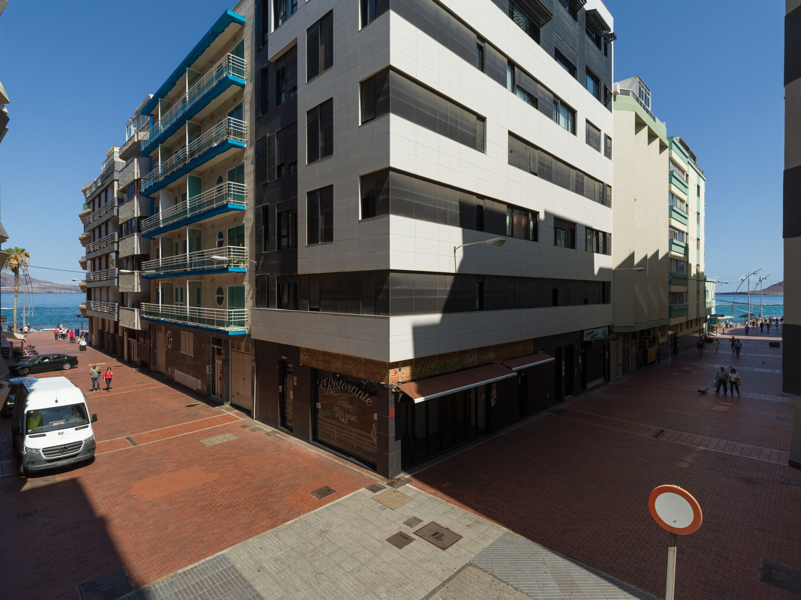 Um edifício de vários andares com um restaurante no andar térreo e área de estacionamento.