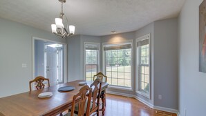 Ein Esszimmer mit Holztisch, Stühlen und einer Kronleuchter.