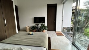 A modern bedroom with a large bed, a flat-screen TV, and potted plants. - Beautiful & Comfortable Suite In The Country Side (Circasia)