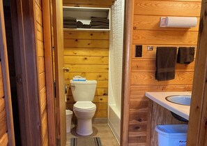 Bathroom features a toilet, sink, and shower curtain.