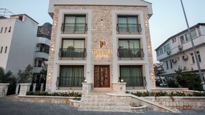 Un immeuble à plusieurs étages, doté d’une façade en pierre, de balcons et d’une entrée centrale avec une porte décorative.