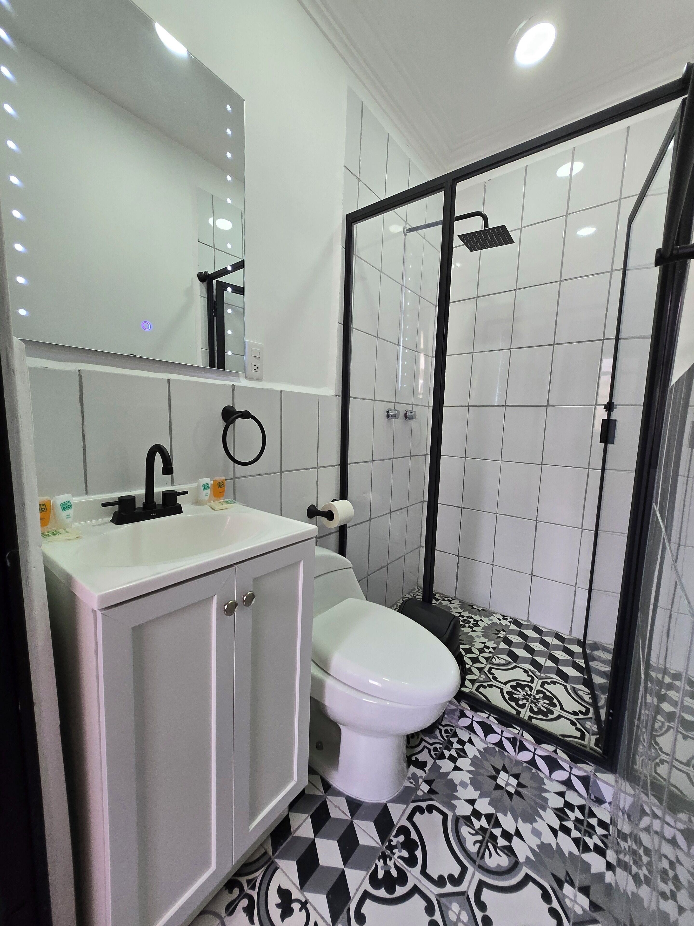 Un bagno con lavandino bianco, WC e zona doccia.