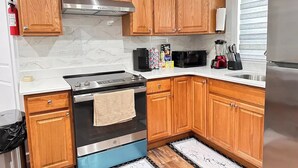A modern kitchen with wooden cabinets, a stainless steel stove, a microwave, and a refrigerator. - "Serene Escape: Leave Worries Behind"
 (Wilkes-Barre)