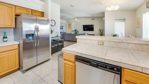 A modern kitchen with stainless steel appliances, wooden cabinets, and a dishwasher.