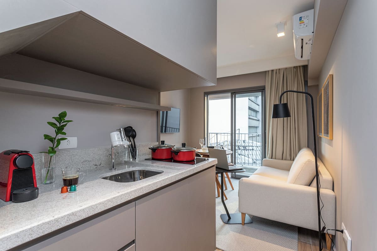 Eine moderne Küche mit Einbauherd, Spüle und Essbereich mit Sofa und Tisch.