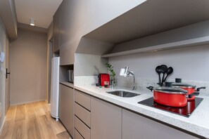 A modern kitchen with a built-in oven, a sink, and a stove. - Next Haddock by Viva - Apartamentos próximos ao MASP e a metros da Estação Consolação e Avenida Paulista (São Paulo)