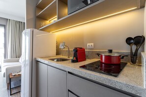 A modern kitchen with a built-in stove, a coffee maker, and a sink. - Next Haddock by Viva - Apartamentos próximos ao MASP e a metros da Estação Consolação e Avenida Paulista (São Paulo)