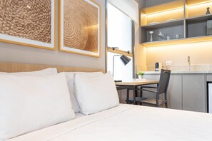 A hotel room with a bed, a desk, and a kitchenette. - Next Haddock by Viva - Apartamentos próximos ao MASP e a metros da Estação Consolação e Avenida Paulista (São Paulo)