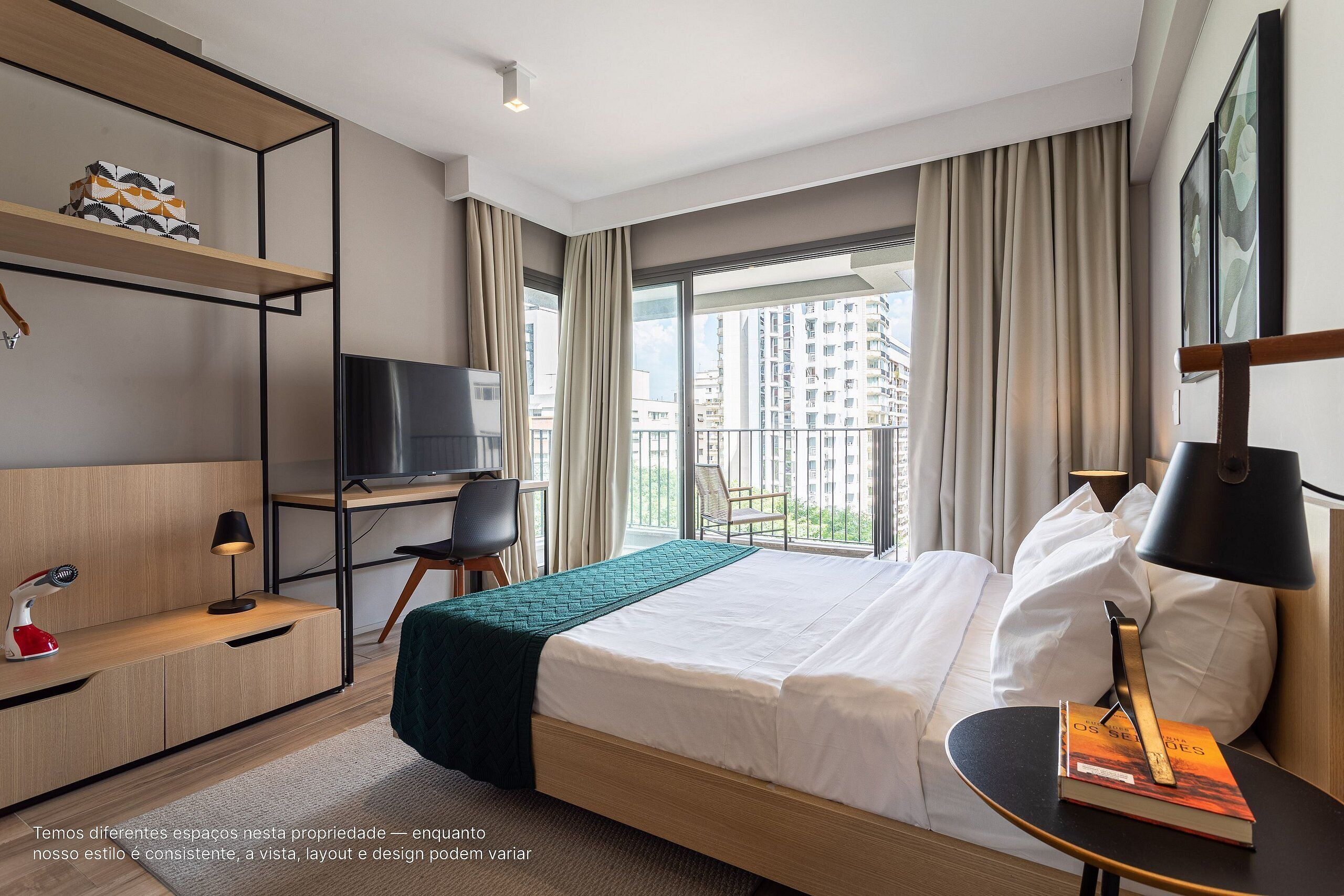 Habitació d'hotel amb un llit, un escriptori, una cadira, un televisor i una prestatgeria.