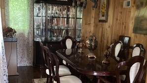 Un comedor con una mesa de madera, seis sillas y una araña.