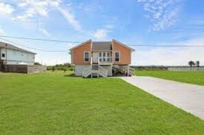 Situated on a well-maintained lawn, this charming home features a front porch and a small staircase leading to the entrance.
