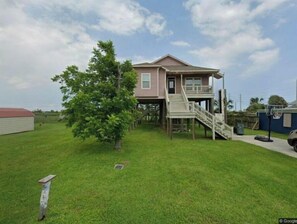 Stylish two-story home with a spacious balcony and well-manicured lawn, offering a basketball hoop for guests to enjoy.