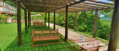 A covered outdoor seating area with wooden benches and a pergola structure.