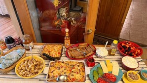 A dining table with various dishes including a casserole, fried items, and fresh fruits. - Bear Creek Guest Ranch (Essex)