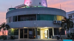 A multi-story building with a cylindrical tower, a covered balcony, and a ground-level entrance. - Isla Mazatlán Residence Club (Mazatlán)
