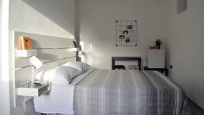A modern bedroom with a bed, bedside table, lamp, and a wall-mounted artwork. - B & B Family in the heart of the Village of Aieta (Cs) (Aieta)