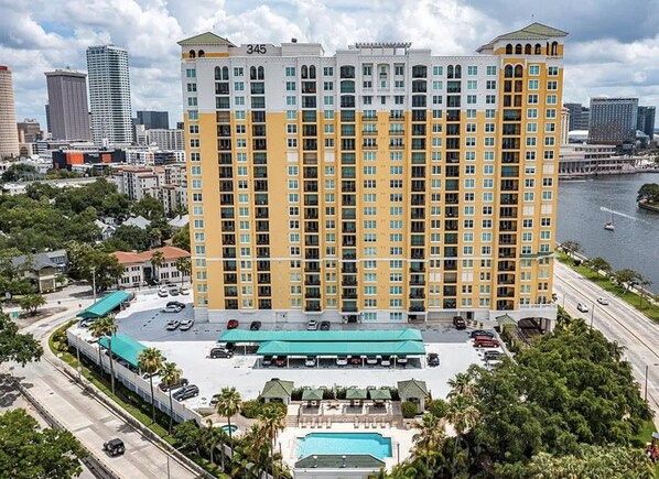 A high-rise hotel with a pool, located near a body of water and a road. - Luxury High Rise Penthouse - Tampa/Bayshore (Tampa)