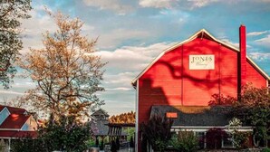 Un granero rojo con un letrero que dice "Jones Winery".