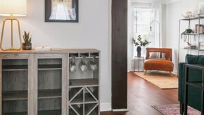 A modern living room with a wooden cabinet, a floor lamp, and a framed artwork on the wall.