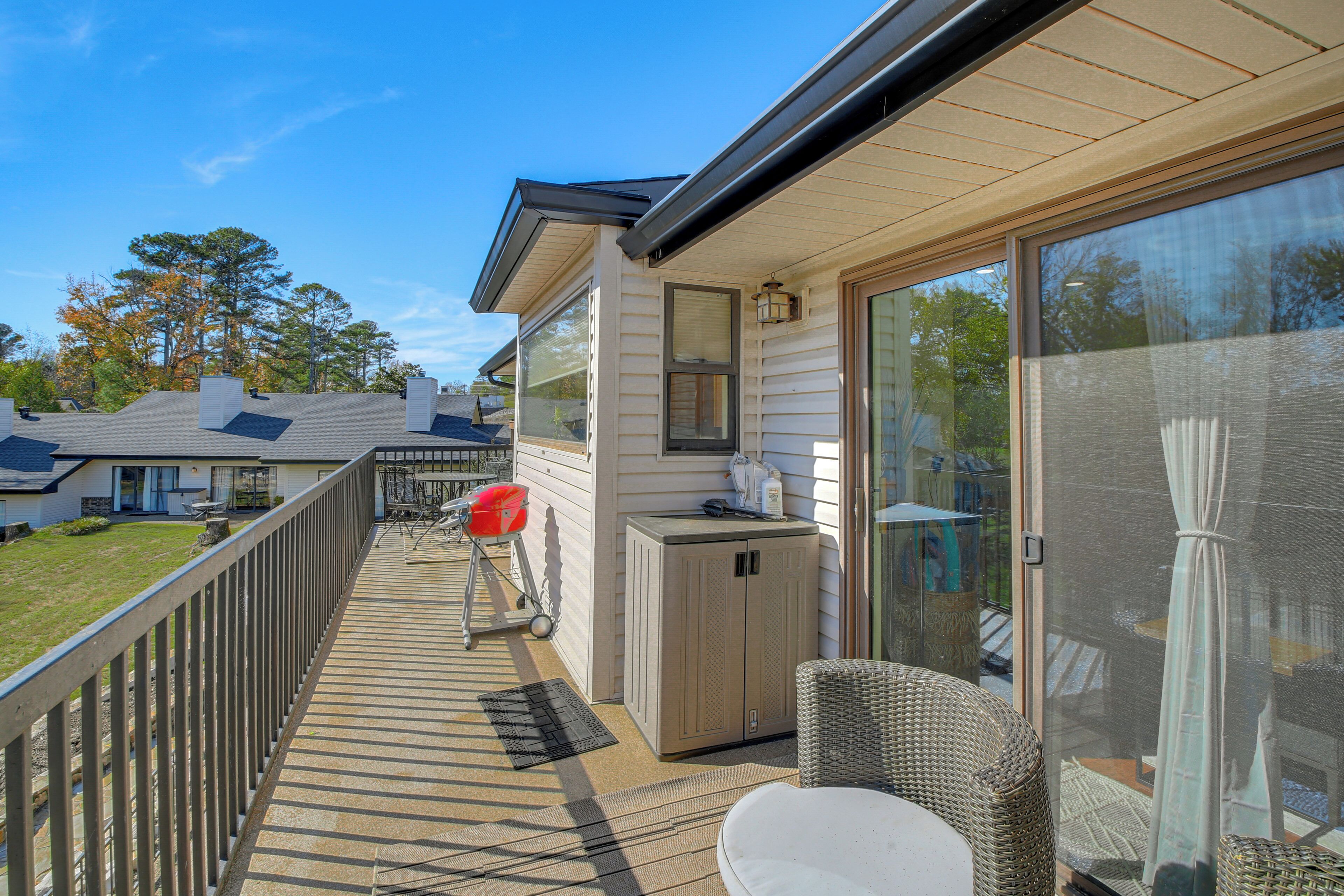 Une terrasse dotée de mobilier d’extérieur, d’un barbecue et d’une porte-fenêtre coulissante donnant sur un patio abrité.