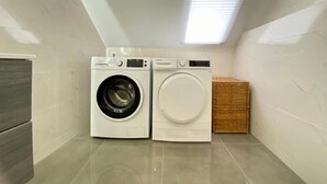 Een wasserette met twee wasmachines en een droogrek.