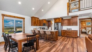 Una cocina amplia con armarios de madera, una isla grande y vistas al campo.