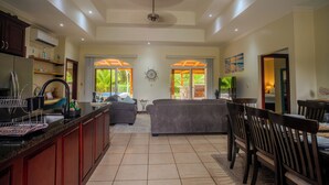 Een ruime woonkamer met keuken, eethoek en uitzicht op de omgeving.