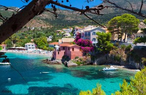 A coastal village with clear turquoise waters, a beach, and colorful buildings. - Impressive Stone Villa, A/C, Private Pool, Sweeping Sea Views to Assos Bay & Magnificent Sunsets! (Defaranata)
