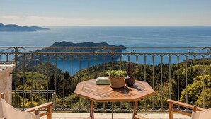 A balcony with a table, a potted plant, and a book. - Impressive Stone Villa, A/C, Private Pool, Sweeping Sea Views to Assos Bay & Magnificent Sunsets! (Defaranata)