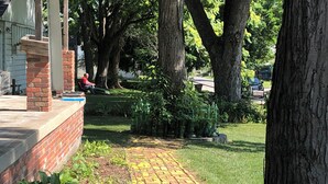 A brick pathway leading to a building with a brick column and a covered porch.
