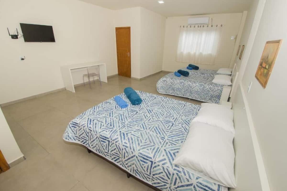 A room with two beds, a desk, and a chair.