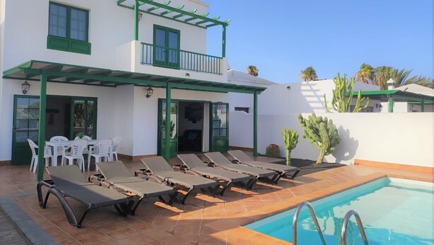 A two-story building with a pool area, including sun loungers and a covered patio. - Villa Martina, Lugar Ideal Para Disfrutar Sol@ o en Familia (Playa Blanca)