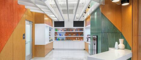 Una cocina moderna con encimeras blancas, detalles de madera y una isla central con taburetes.
