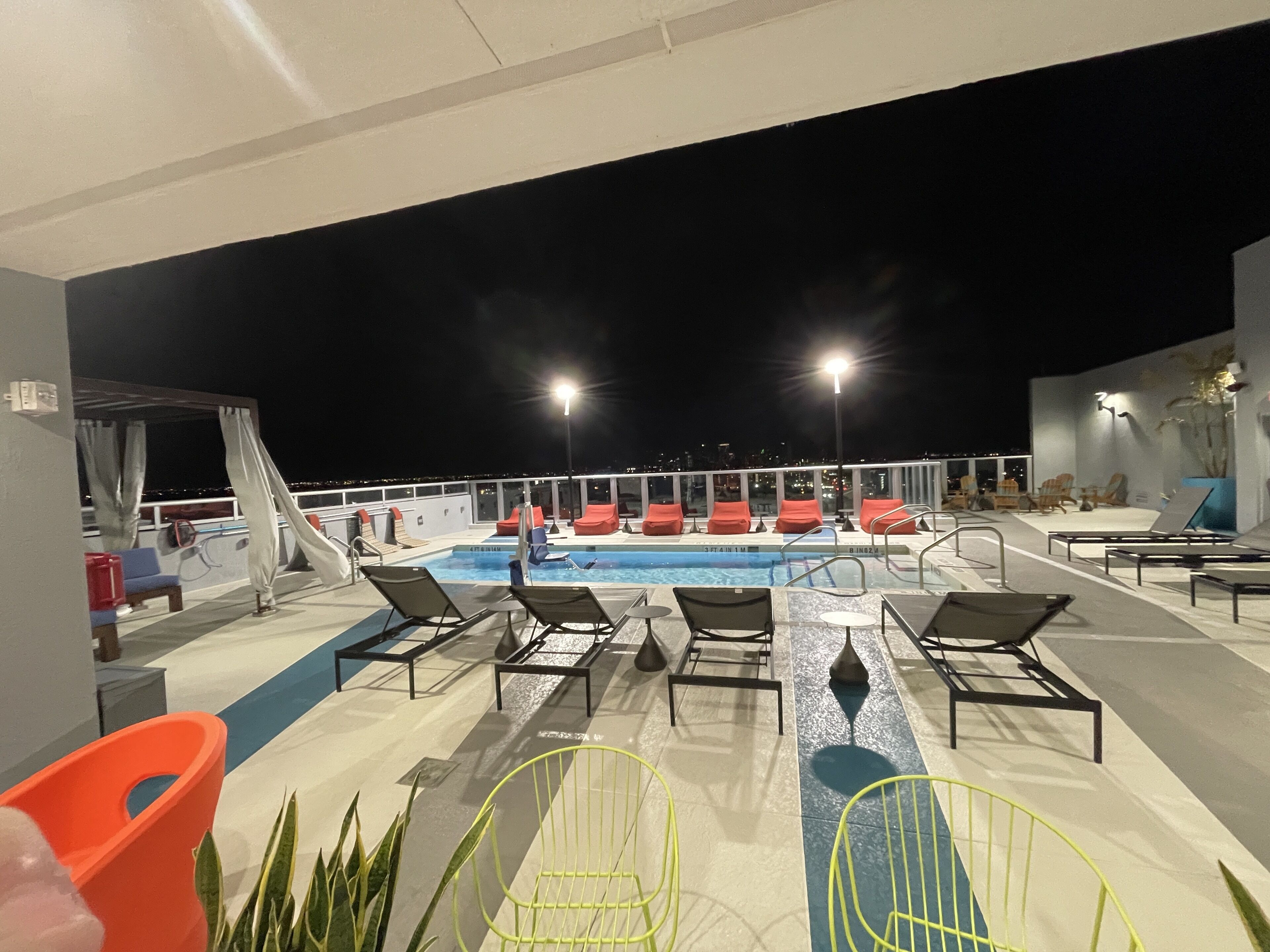 A rooftop pool area with lounge chairs and a swimming pool.