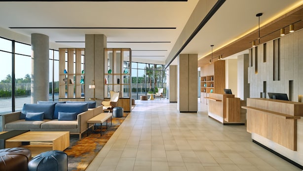 A spacious lobby with a reception desk, seating area, and large windows offering a view of the outdoors. - Fairfield By Marriott Jakarta Soekarno-Hatta Airport (Jakarta)