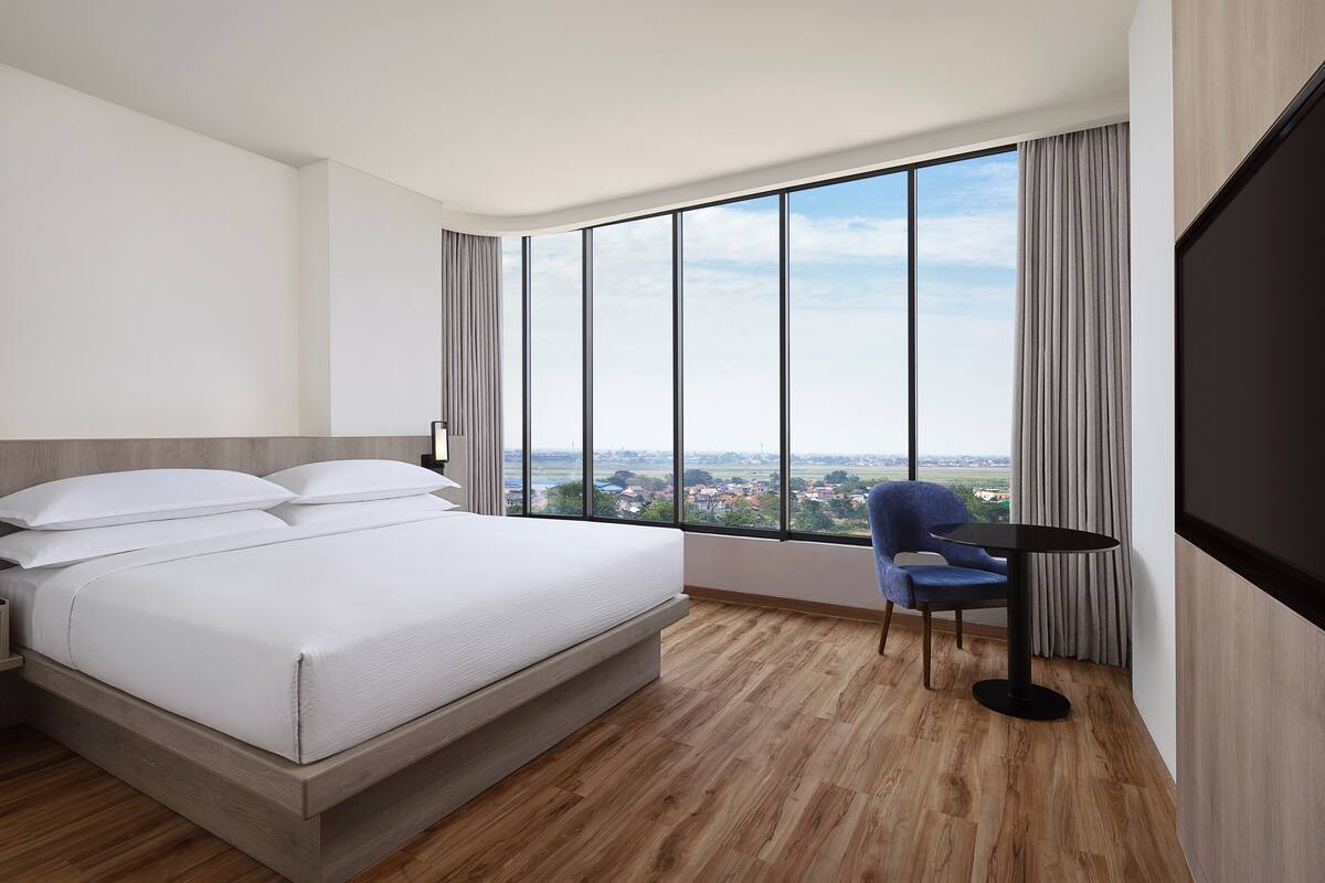 deluxe room, 1 king bed, non smoking, city view (corner, free airport shuttle) | premium bedding, in-room safe, desk, laptop workspace