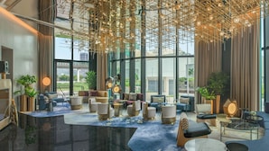 A modern hotel lobby with a spacious seating area, large windows offering city views, and contemporary decor. - W Macau - Studio City (Cotai)