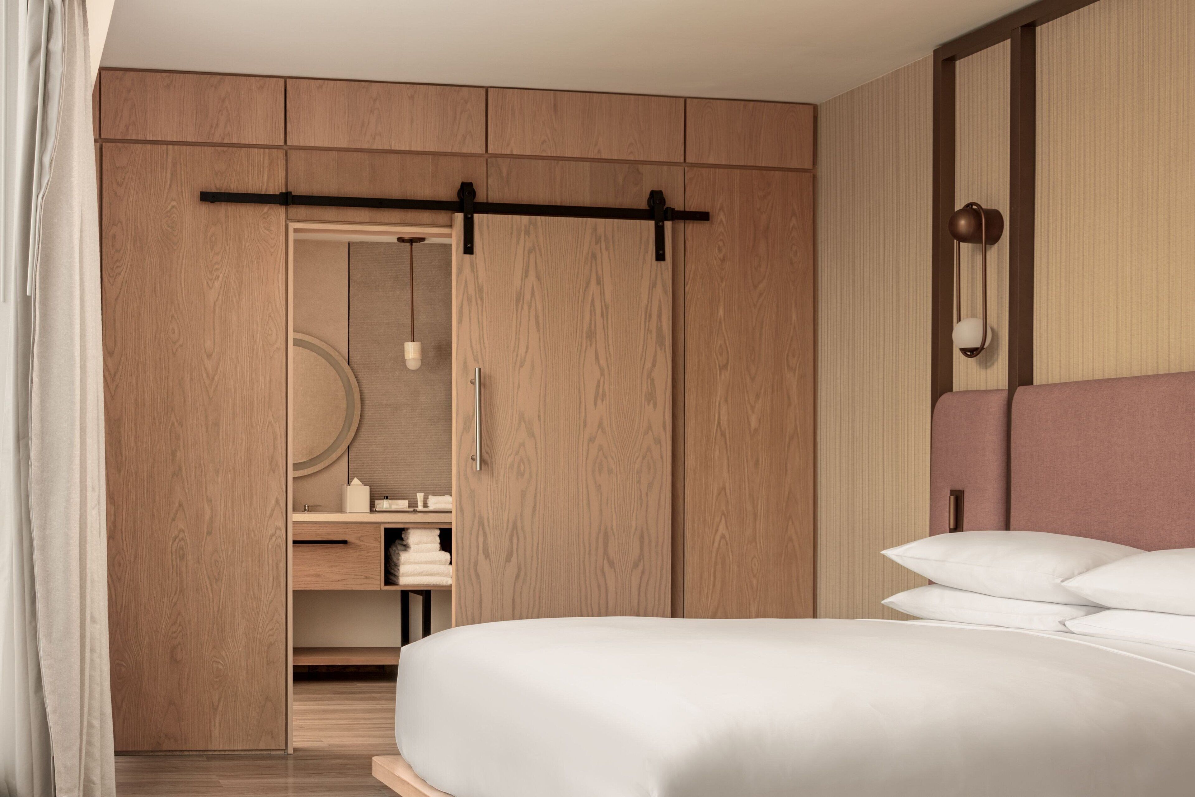 Ein Schlafzimmer mit einem Bett, einem Schrank mit Schiebetür, einem Nachttisch und einem Spiegel.