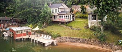 A lakeside property with a house, dock, and swimming area.