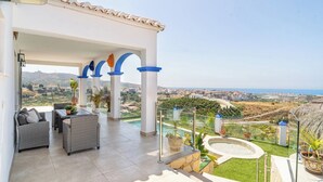 A covered outdoor area with seating, a pool, and a view of a coastal landscape. - Casa Mirador Azul Torrox by Ruralidays (Málaga)